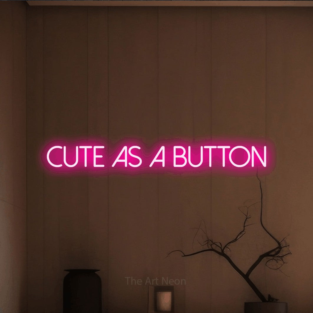 Enseigne néon à DEL à lumière rose vif, affichant « Cute as a Button » sur un mur brun chaleureux, pour décorer une chambre de bébé