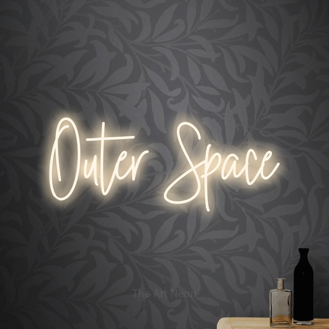 Enseigne néon à DEL à lumière blanche chaude, de style manuscrit, affichant « Outer Space » sur un papier peint floral gris pâle, pour décorer une chambre de bébé