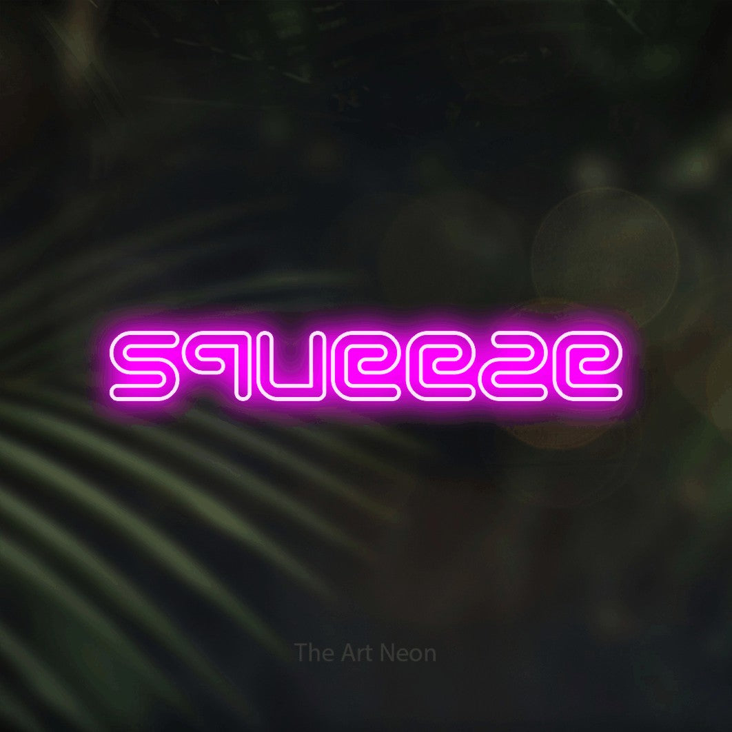 Pink outline-style LED neon sign reading "Squeeze" against dark blurred palm leaves for kitchen décor