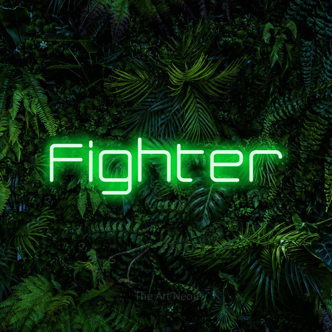 Green LED neon sign reading "Fighter" against a dense tropical foliage wall