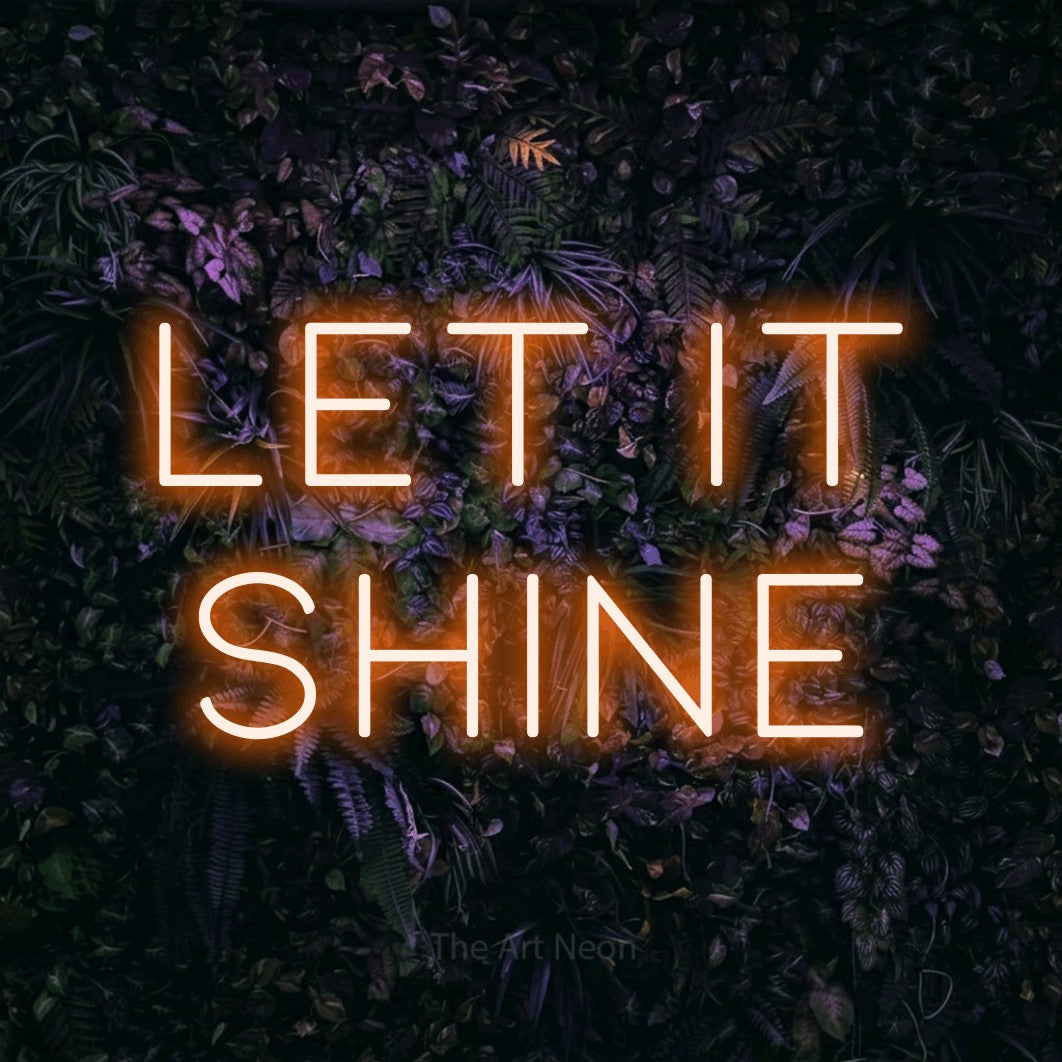 Orange LED neon sign reading "Let It Shine" against a purple floral wall