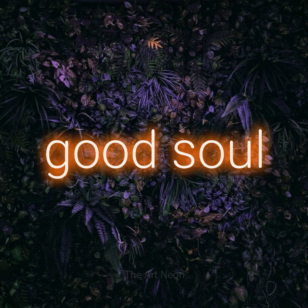 Orange LED neon sign reading "Good Soul" against a purple floral wall