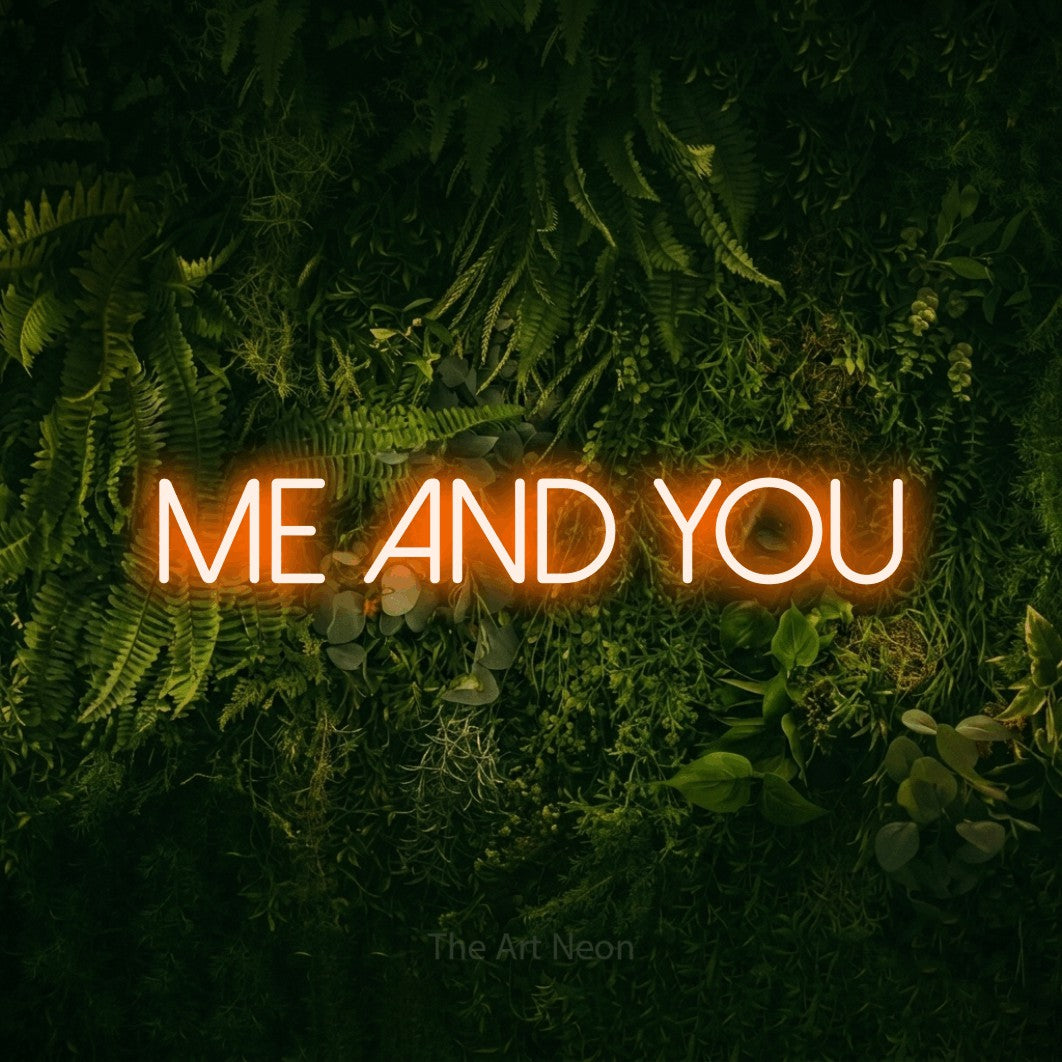 Orange LED neon sign reading "Me and You" against a moss-covered green wall