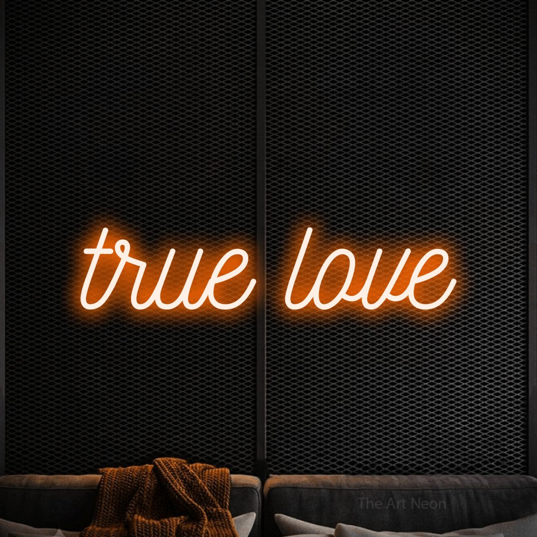 Orange script-style LED neon sign reading "True Love" against a black textured wall