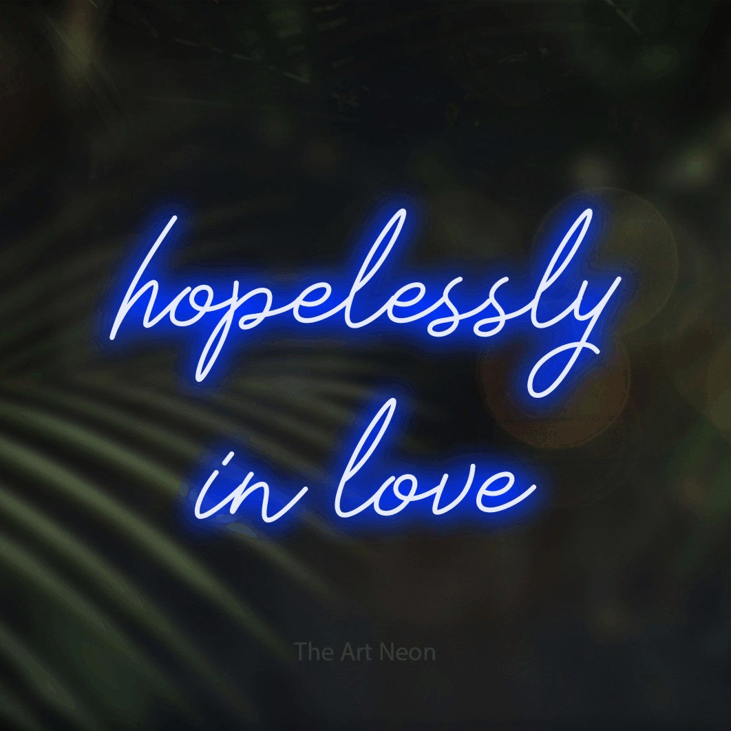 Blue script-style LED neon sign reading "Hopelessly in Love" against dark blurred palm leaves