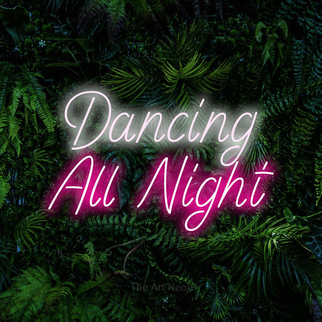 Hot pink and cool white LED neon sign reading "Dancing All Night" against a dense tropical foliage wall for wedding décor
