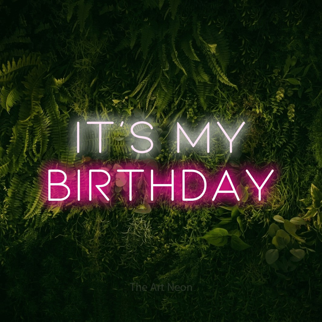 Hot pink and cool white LED neon sign reading "It's My Birthday" against a moss-covered green wall for party décor