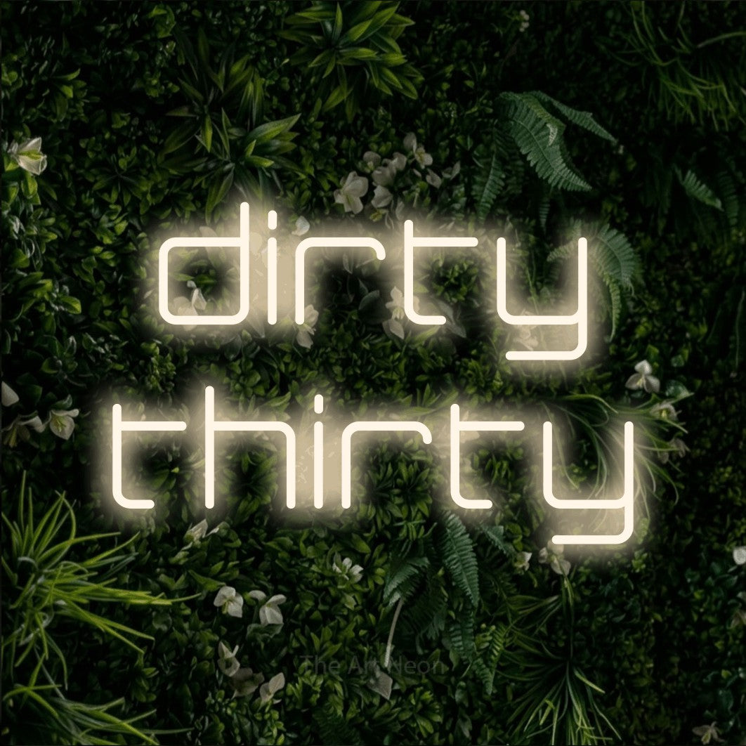 Warm white LED neon sign reading "Dirty Thirty" against a leafy green wall for party décor