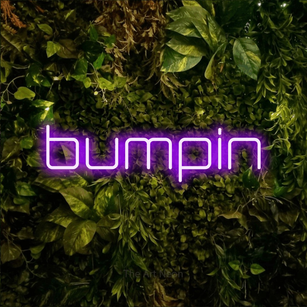Purple LED neon sign reading "Bumpin" against a textured moss and foliage wall