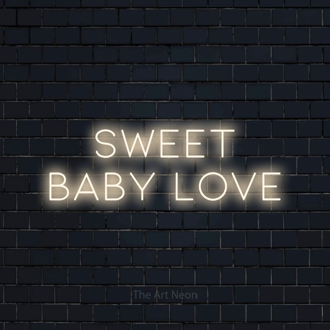 Warm white LED neon sign reading "Sweet Baby Love" against a dark navy brick wall