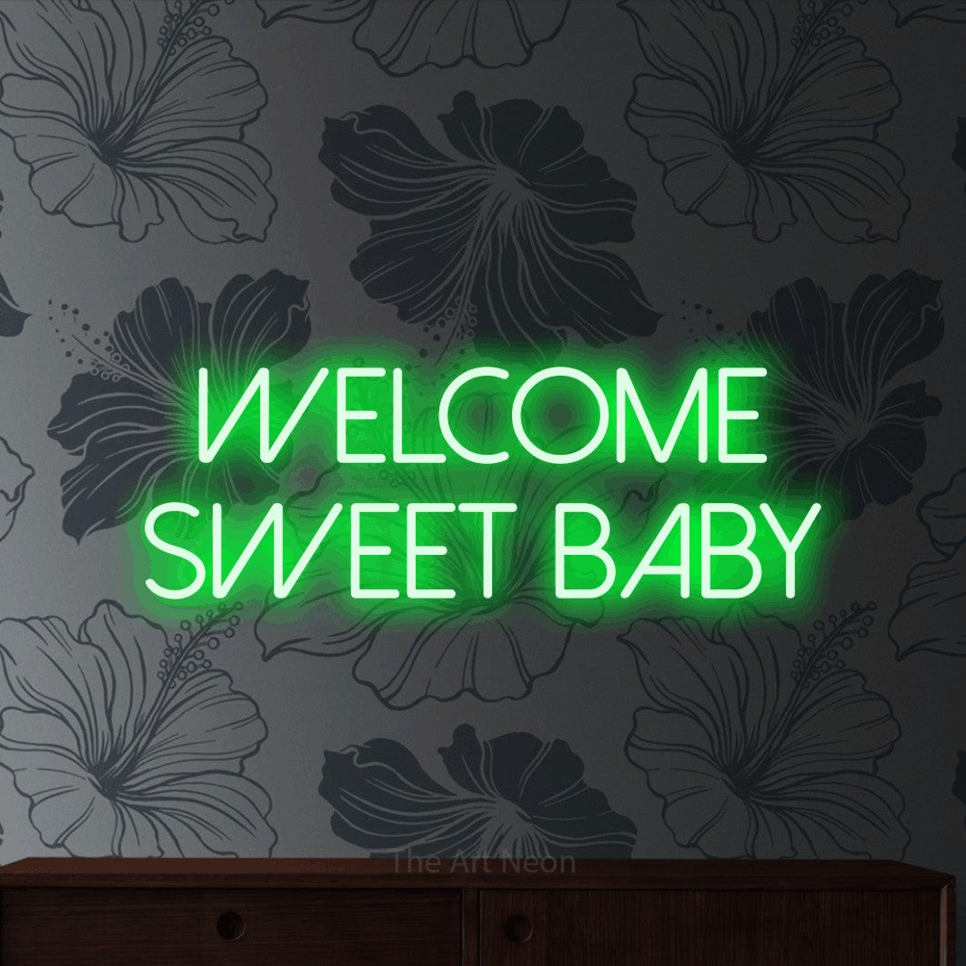Green LED neon sign reading "Welcome Sweet Baby" against grey floral wallpaper