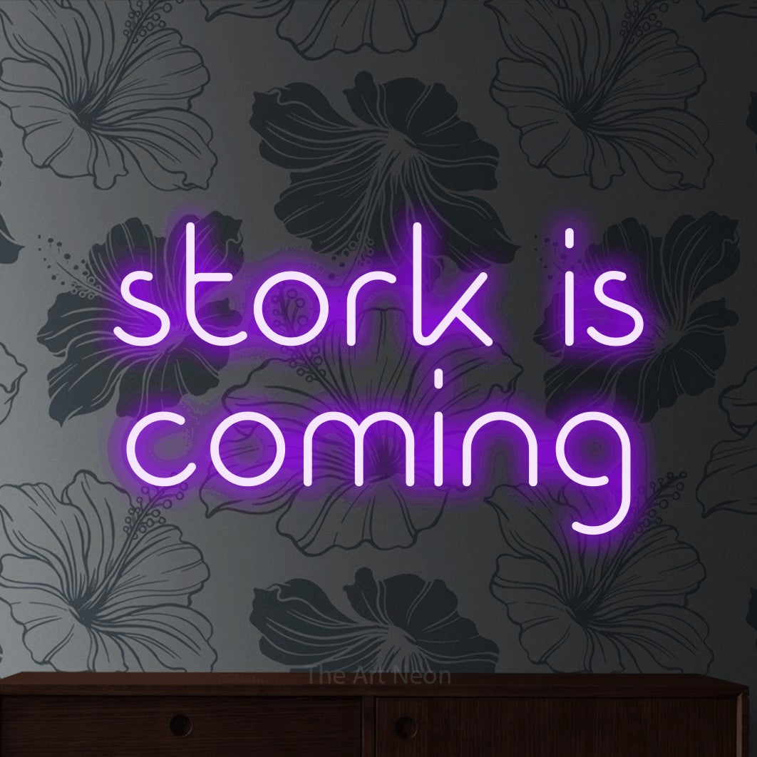 Purple LED neon sign reading "Stork is Coming" against grey floral wallpaper