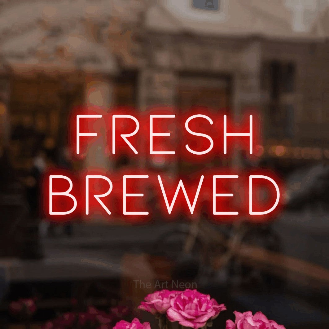 Red LED neon sign reading "Fresh Brewed" in a softly blurred café interior for café décor