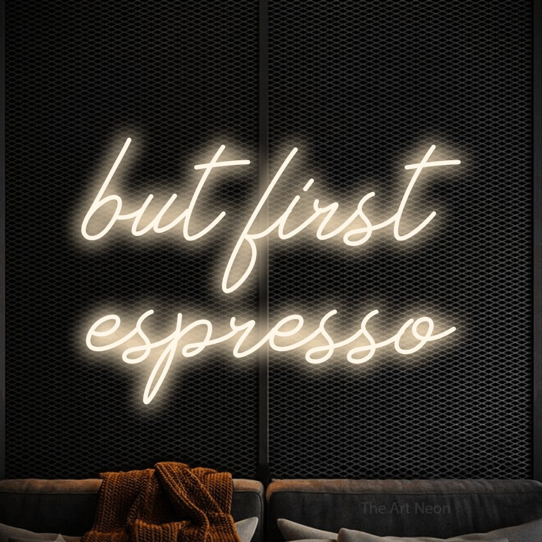Warm white script-style LED neon sign reading "But First Espresso" against a black textured wall for café décor