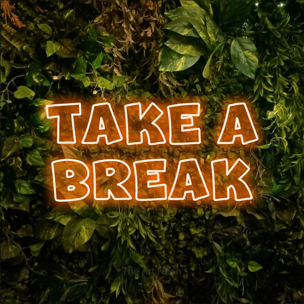 Orange outline-style LED neon sign reading "Take a Break" against a textured moss and foliage wall for café décor