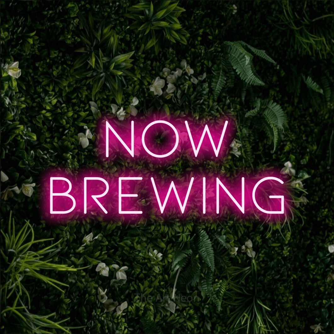 Hot pink LED neon sign reading "Now Brewing" against a leafy green wall for café décor