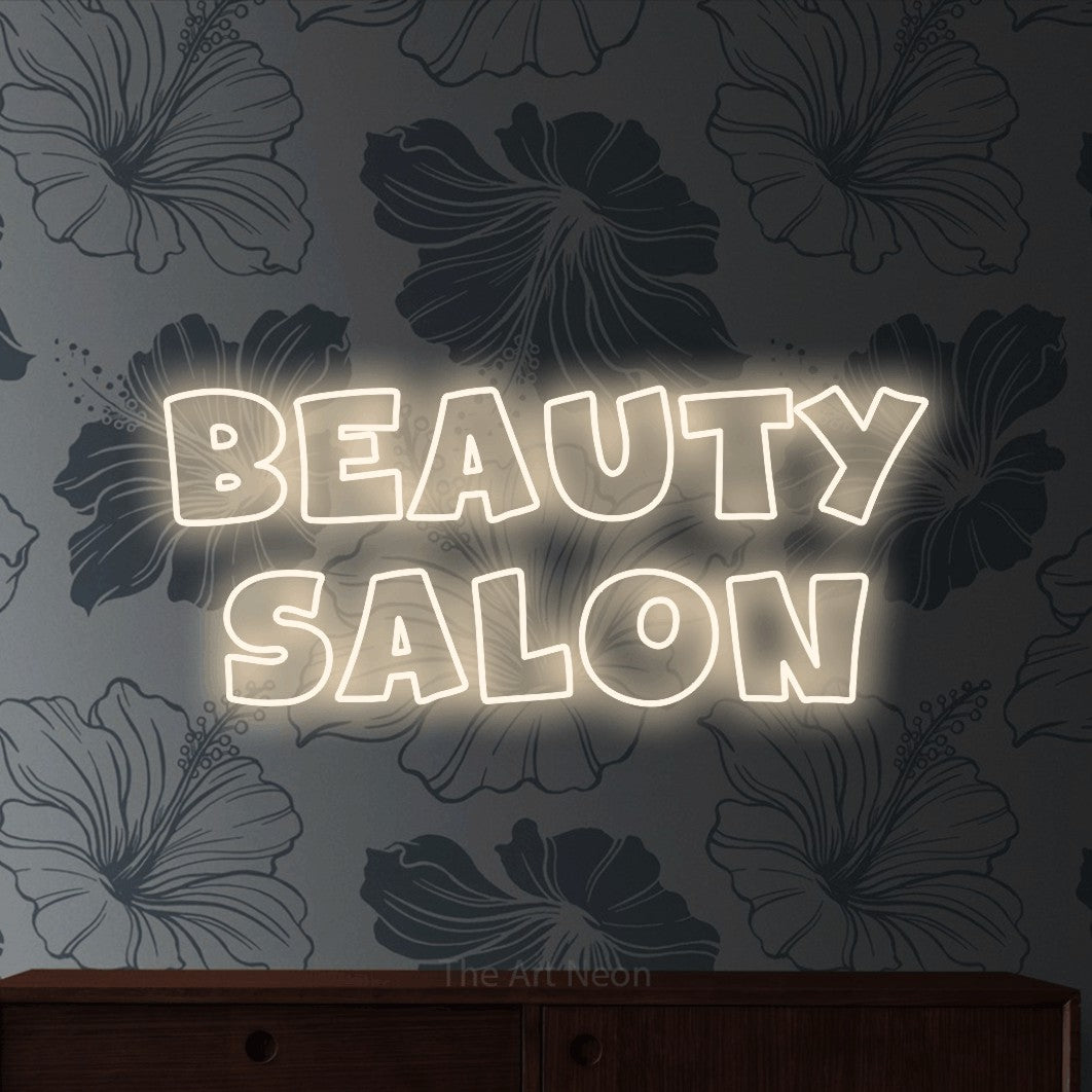 Warm white outline-style LED neon sign reading "Beauty Salon" against grey floral wallpaper for salon décor