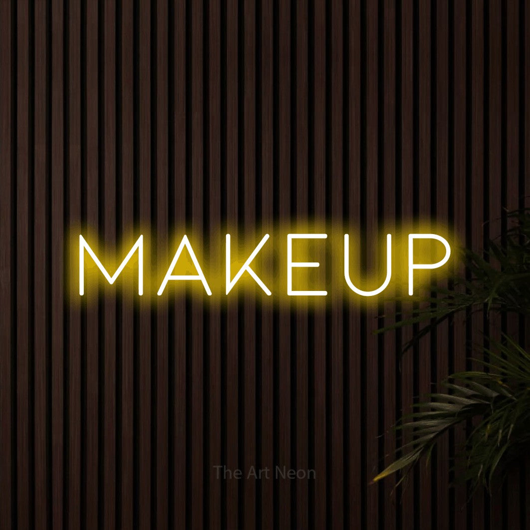 Yellow LED neon sign reading "Makeup" against dark wooden slats for salon décor