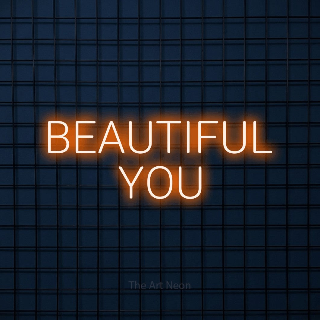 Orange LED neon sign reading "Beautiful You" against a dark blue tiled wall for salon décor