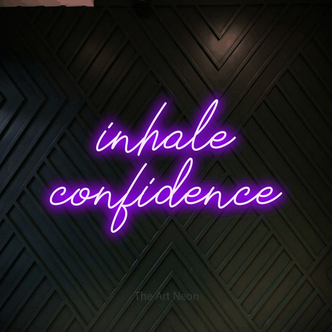 Enseigne néon à DEL à lumière violette, de style manuscrit, affichant « Inhale Confidence » sur un mur géométrique en bois foncé, pour décorer une salle d’entraînement
