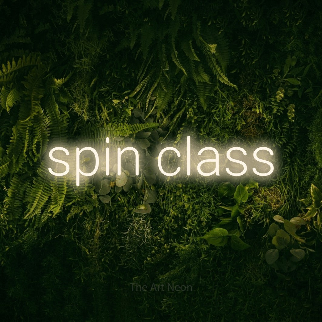 Warm white LED neon sign reading "Spin Class" against a moss-covered green wall for gym décor