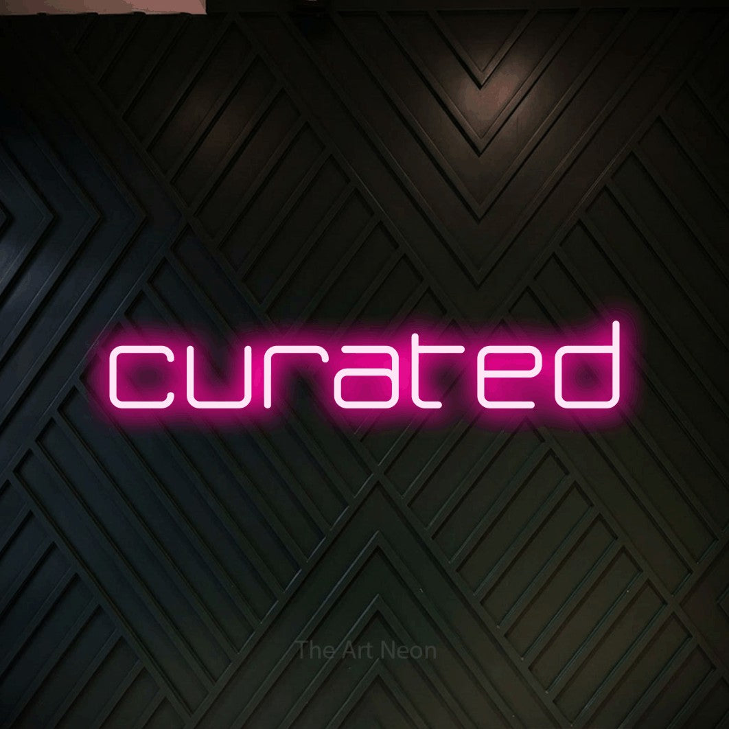 Hot pink LED neon sign reading "Curated" against a dark geometric wood wall
