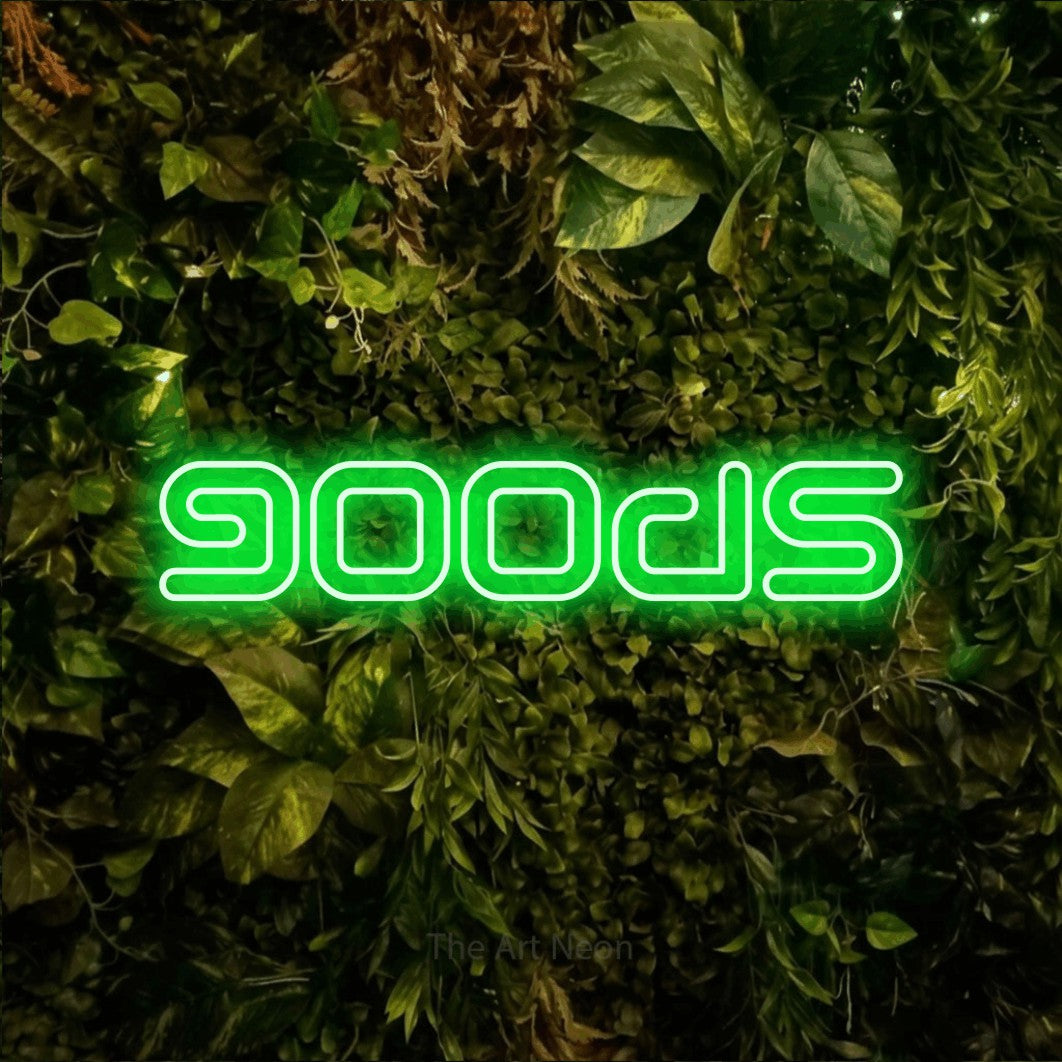 Green outline-style LED neon sign reading "Goods" against a textured moss and foliage wall