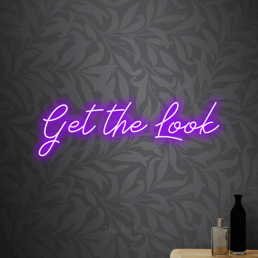 Purple script-style LED neon sign reading "Get the Look" against light grey floral wallpaper