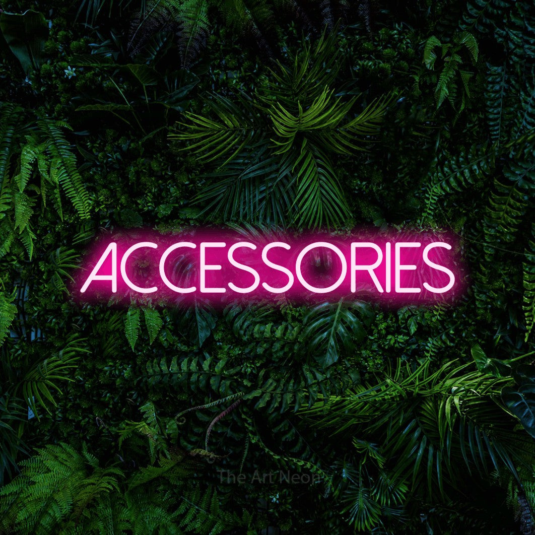 Enseigne néon à DEL à lumière rose vif, affichant « Accessories » sur un mur de feuillage tropical dense