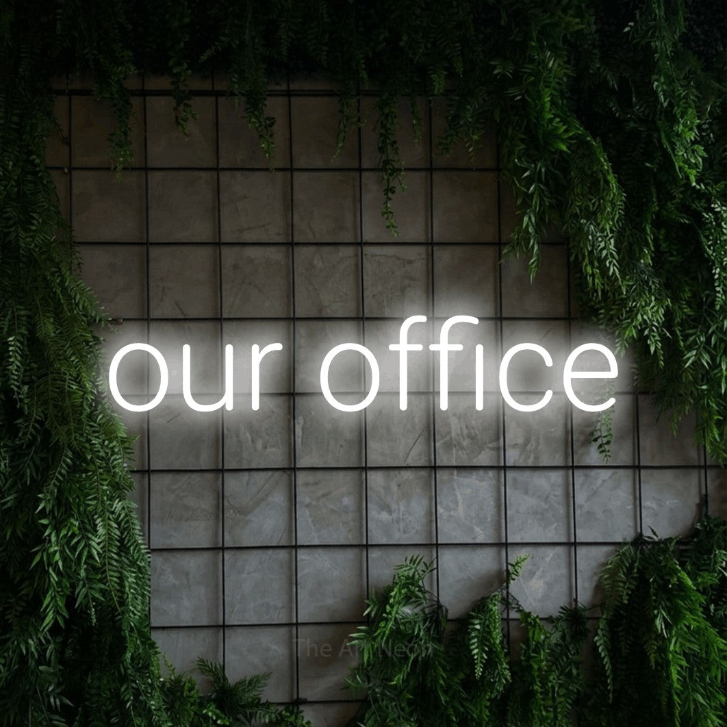Cool white LED neon sign reading "Our Office" against a green grid wall with foliage for office décor