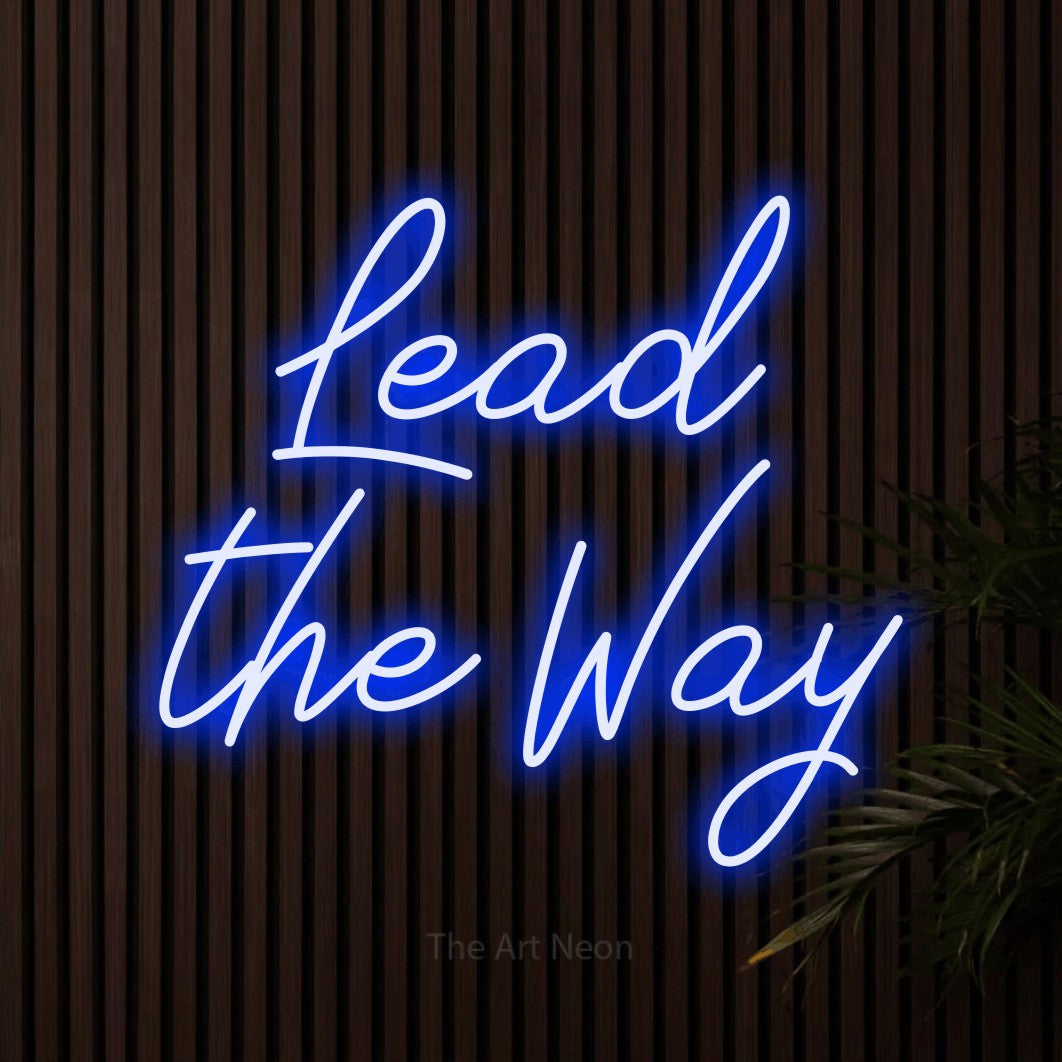 Blue script-style LED neon sign reading "Lead the Way" against dark wooden slats for office décor