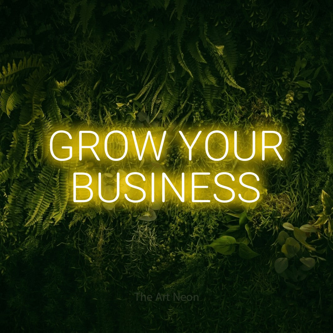 Yellow LED neon sign reading "Grow Your Business" against a moss-covered green wall for office décor