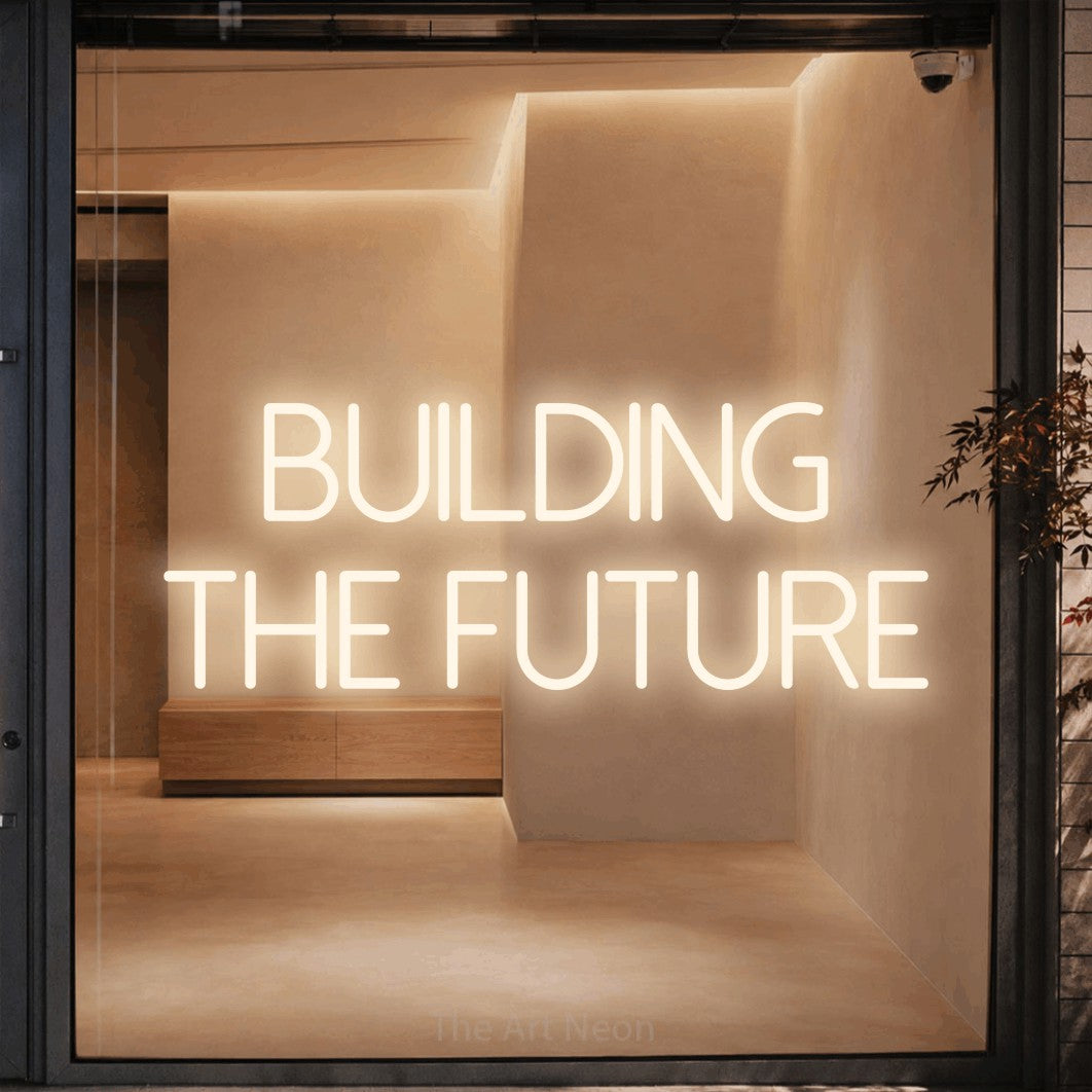 Warm white LED neon sign reading "Building the Future" against a warm beige alcove wall for office décor