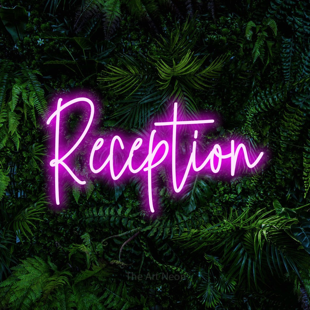 Pink script-style LED neon sign reading "Reception" against a dense tropical foliage wall for hotel décor