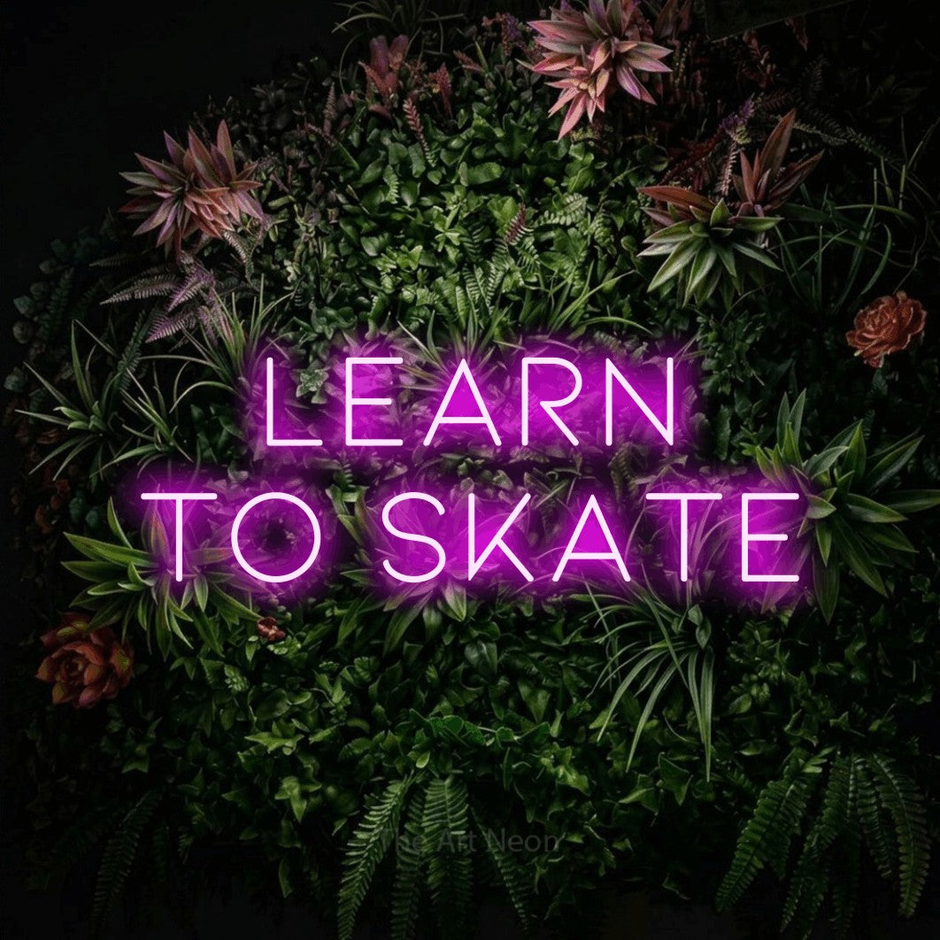 Pink LED neon sign reading "Learn to Skate" against a flowering garden wall