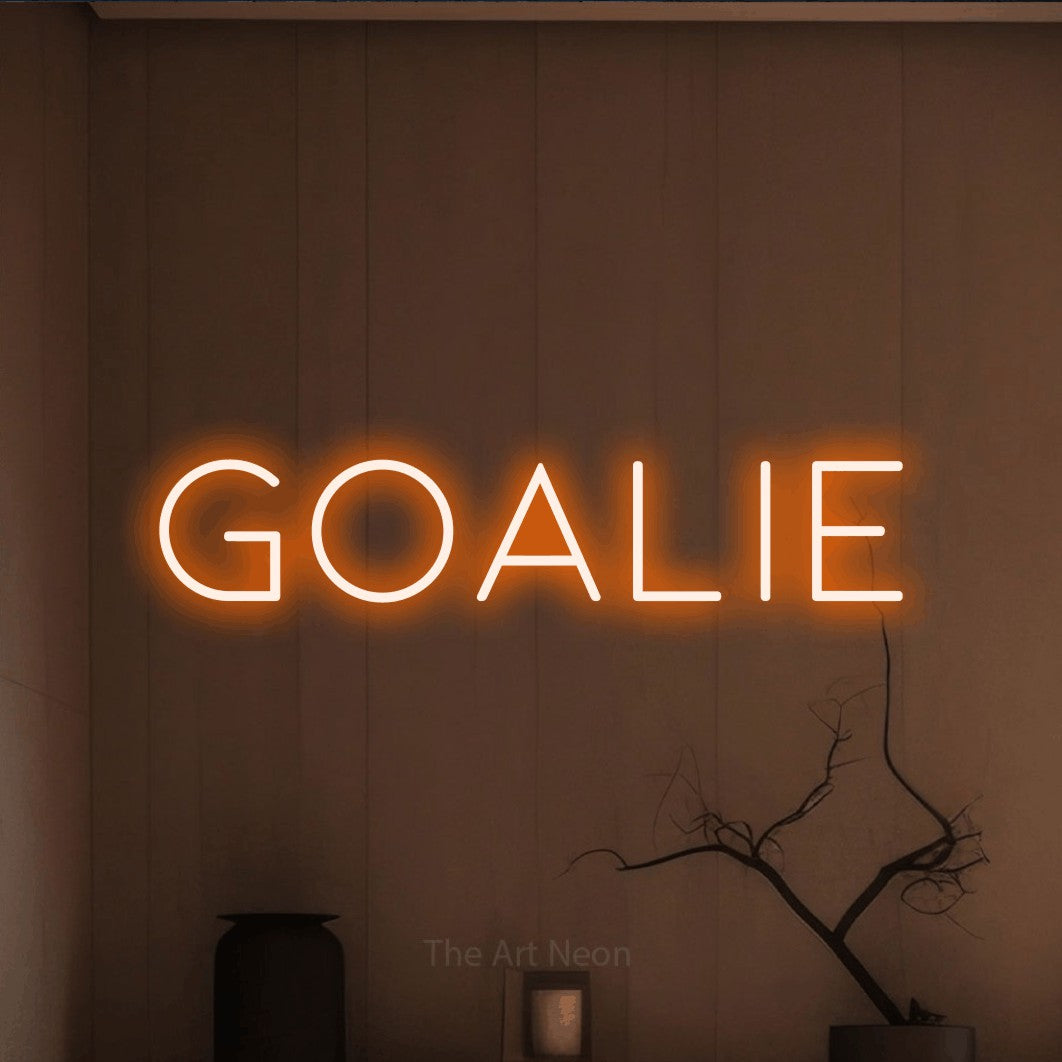 Orange LED neon sign reading "Goalie" against a warm brown wall