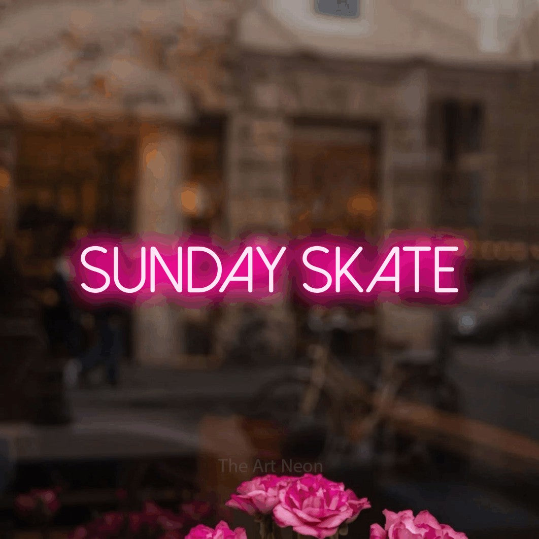 Hot pink LED neon sign reading "Sunday Skate" in a softly blurred café interior
