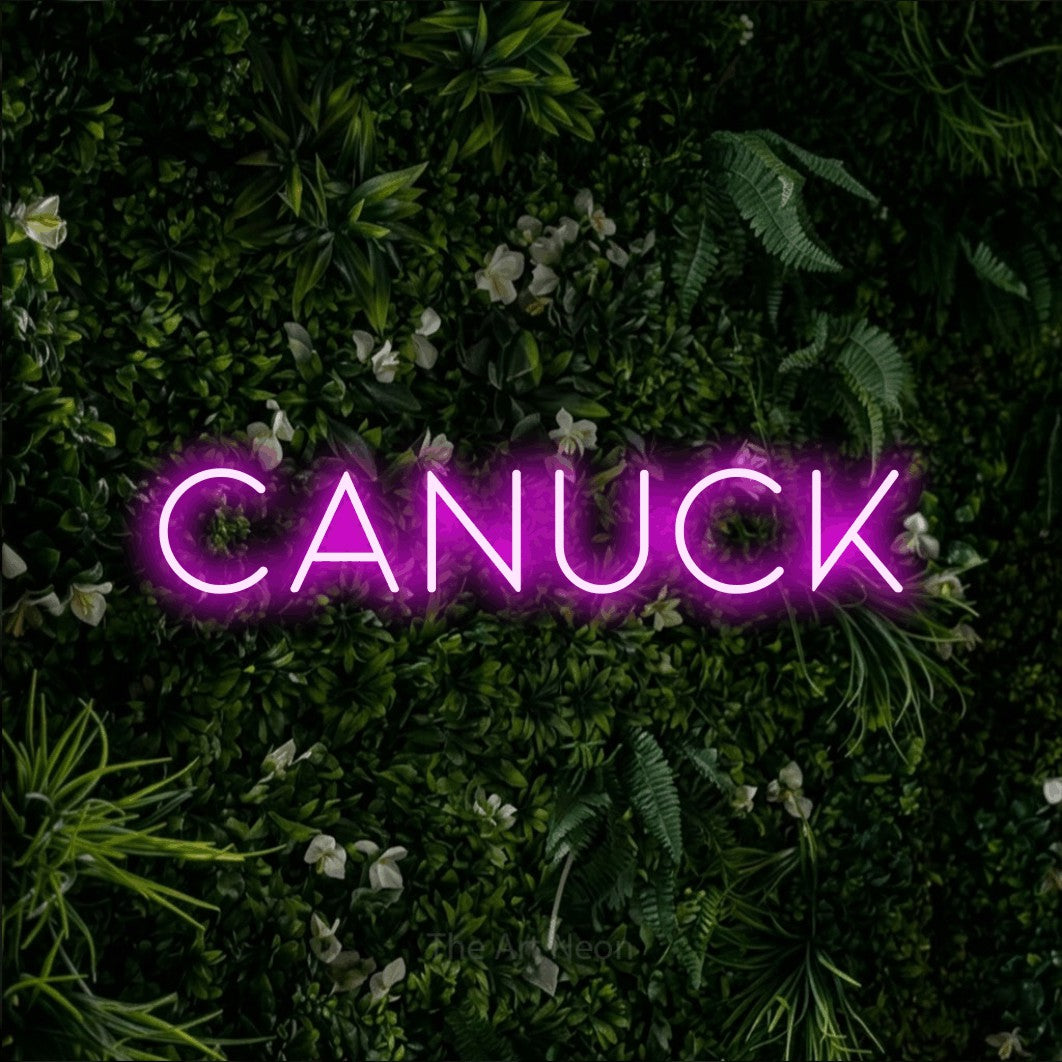 Pink LED neon sign reading "Canuck" against a leafy green wall