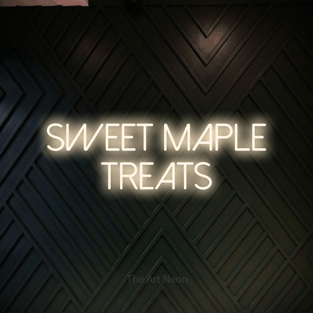 Warm white LED neon sign reading "Sweet Maple Treats" against a dark geometric wood wall