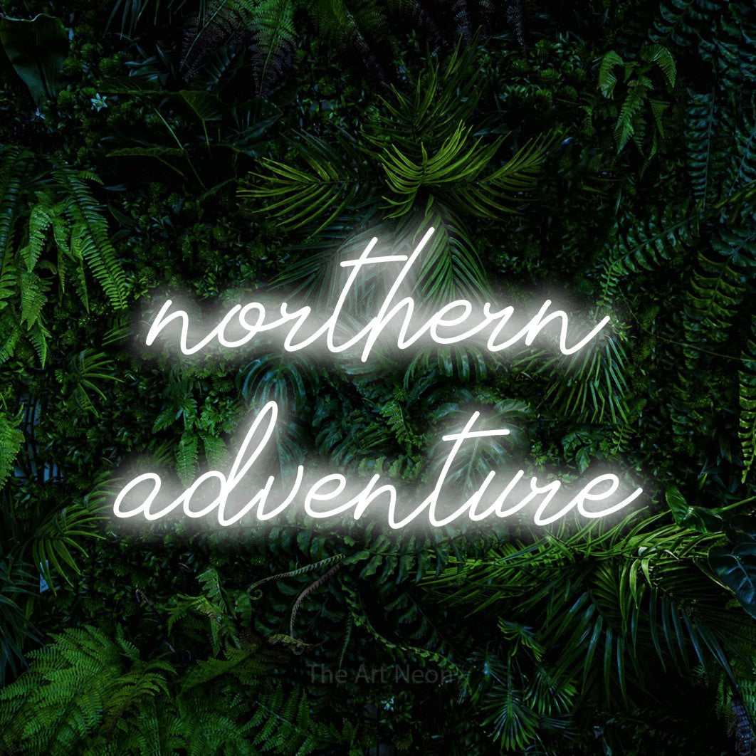 Cool white script-style LED neon sign reading "Northern Adventure" against a dense tropical foliage wall