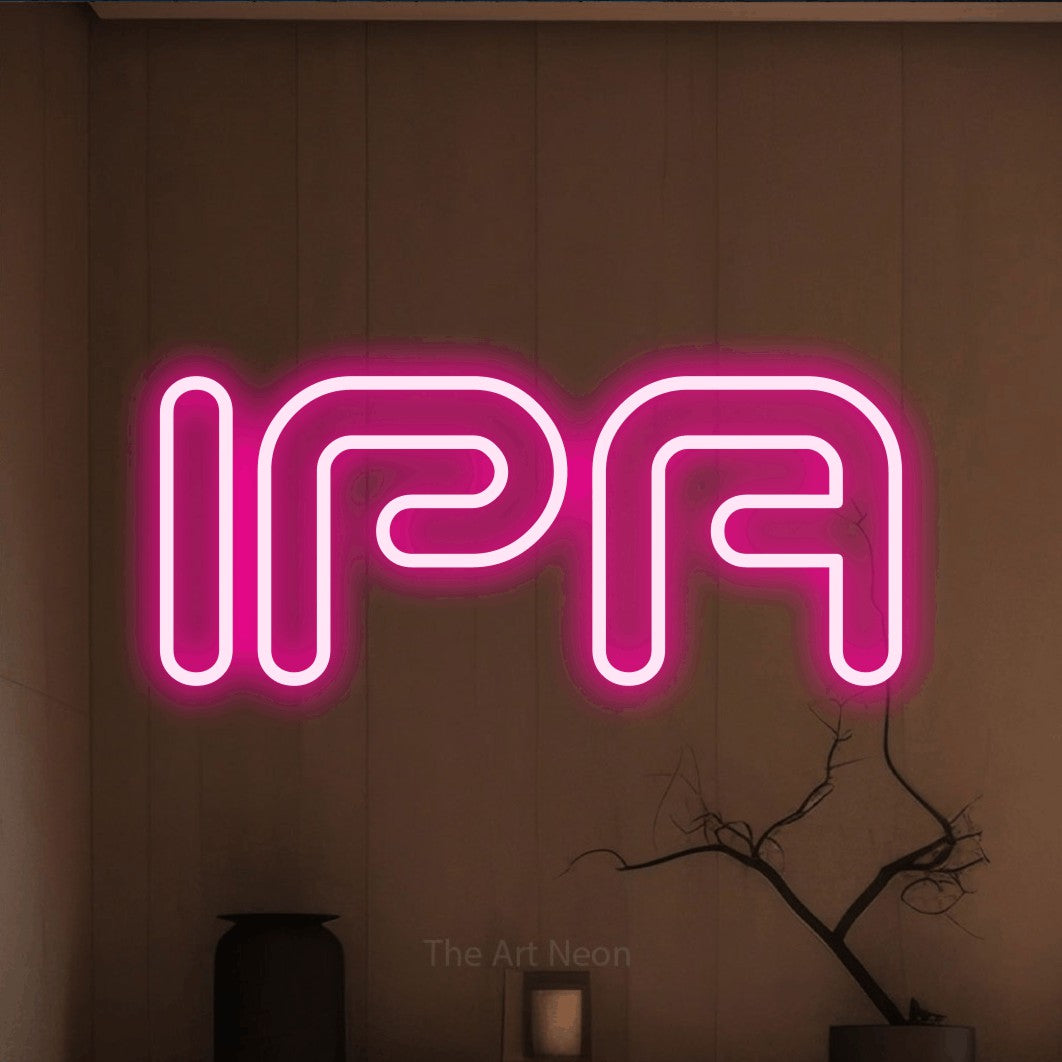 Hot pink outline-style LED neon sign reading "IPA" against a warm brown wall