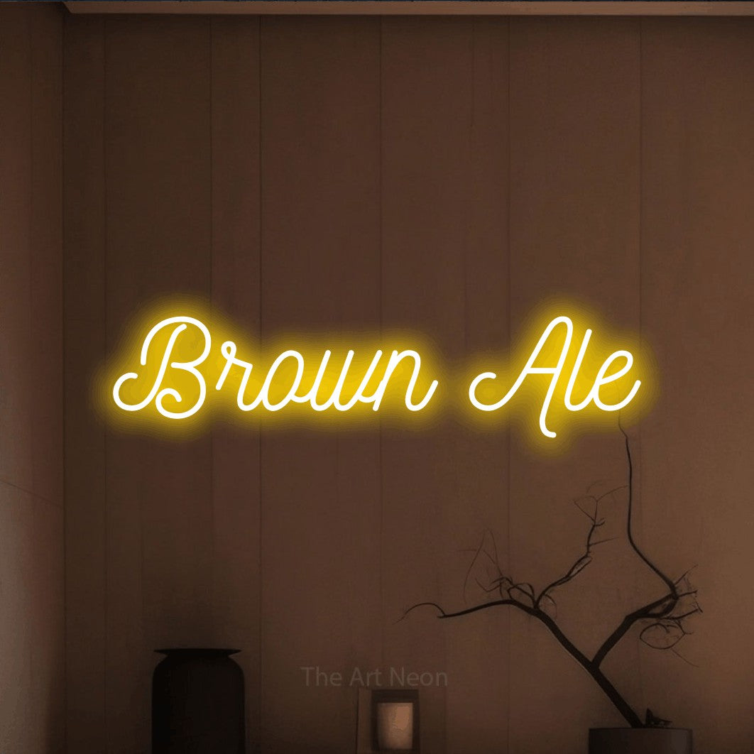 Yellow script-style LED neon sign reading "Brown Ale" against a warm brown wall