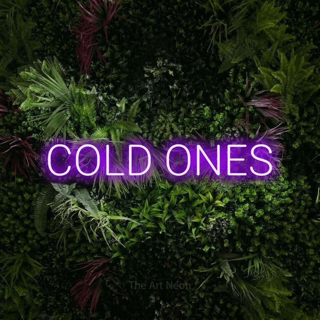 Purple LED neon sign reading "Cold Ones" against a lush garden wall with pink flowers