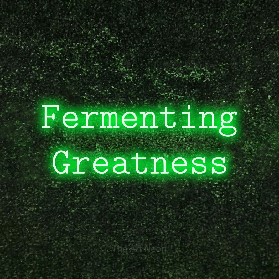 Green LED neon sign reading "Fermenting Greatness" against a textured green moss wall
