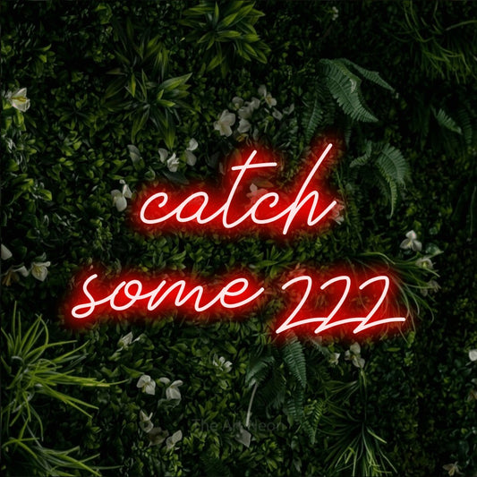 Red script-style LED neon sign reading "Catch Some Zzz" against a leafy green wall for bedroom décor