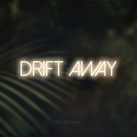 Warm white LED neon sign reading "Drift Away" against dark blurred palm leaves for bedroom décor