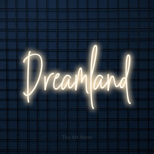 Warm white script-style LED neon sign reading "Dreamland" against a dark blue tiled wall for bedroom décor