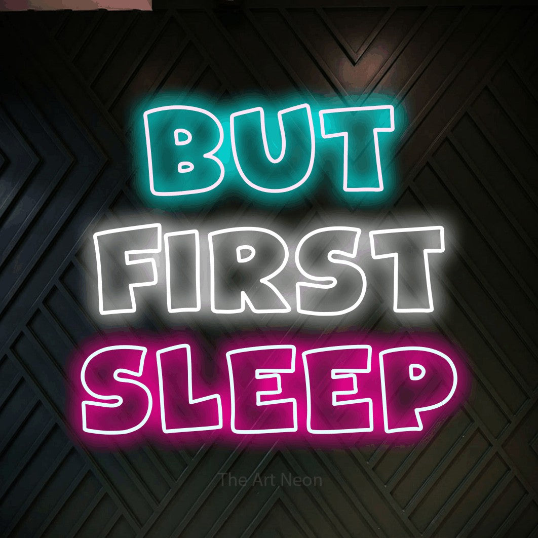 Multicolour outline-style LED neon sign reading "But First Sleep" against a dark geometric wood wall for bedroom décor