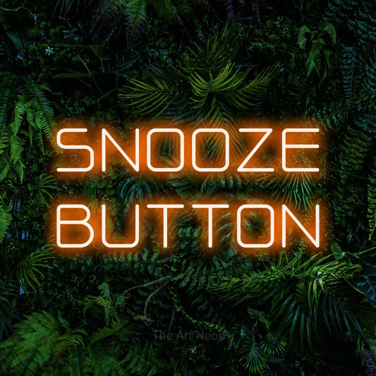 Orange LED neon sign reading "Snooze Button" against a dense tropical foliage wall for bedroom décor