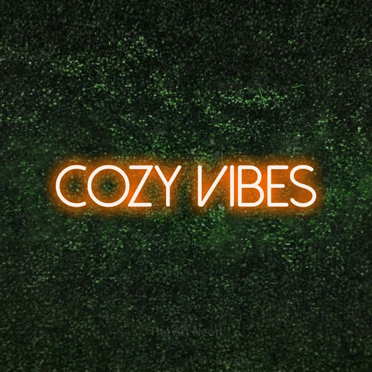 Orange LED neon sign reading "Cozy Vibes" against a textured green moss wall for bedroom décor